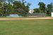 Outfield view looking at baseball field. Practice net in background
